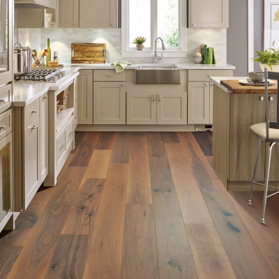 Wide-plank hardwood flooring in a bright Ann Arbor kitchen with white cabinets and farmhouse sink